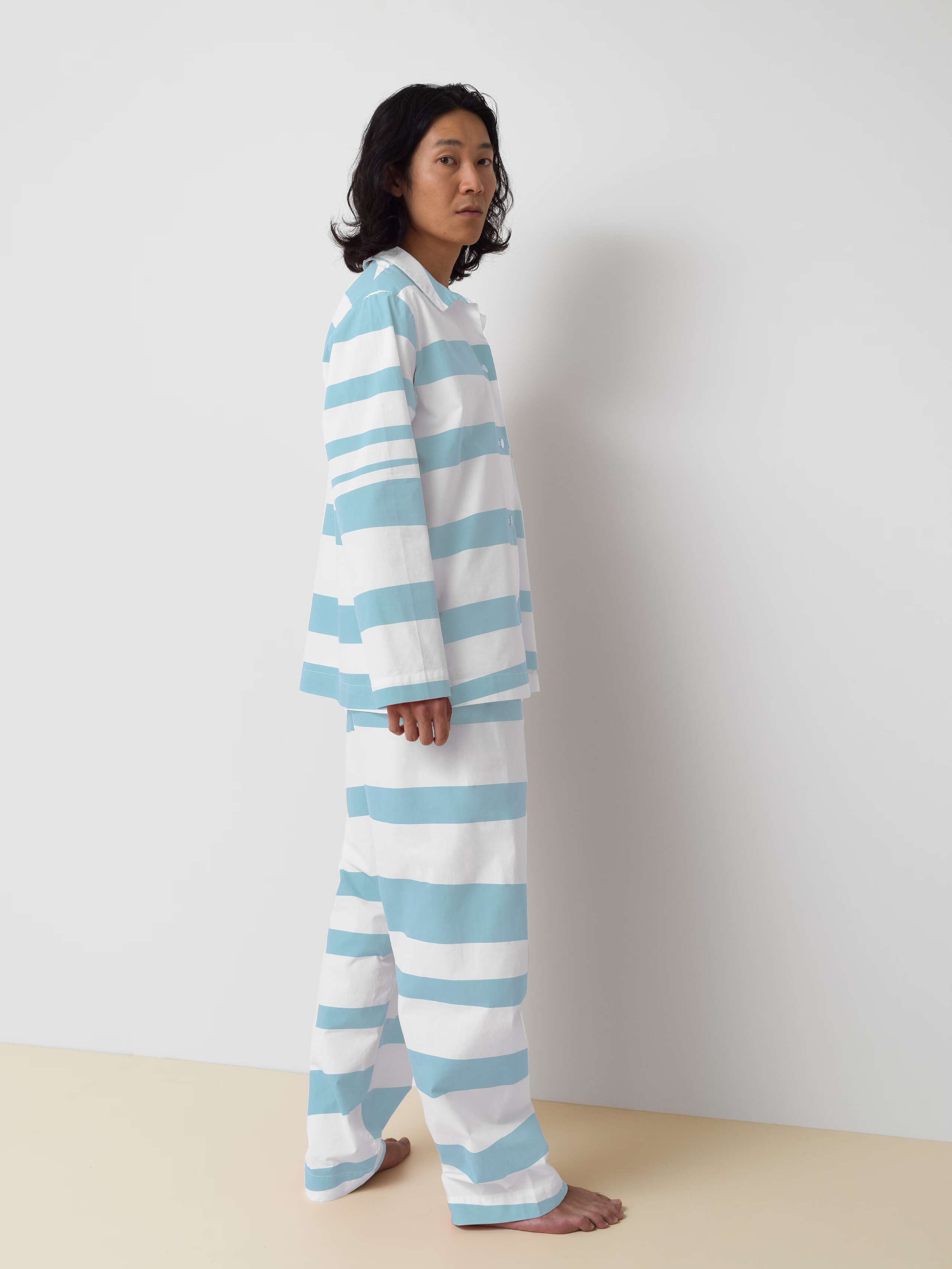 Picture of a man wearing a cotton pyjama featuring blue stripes
