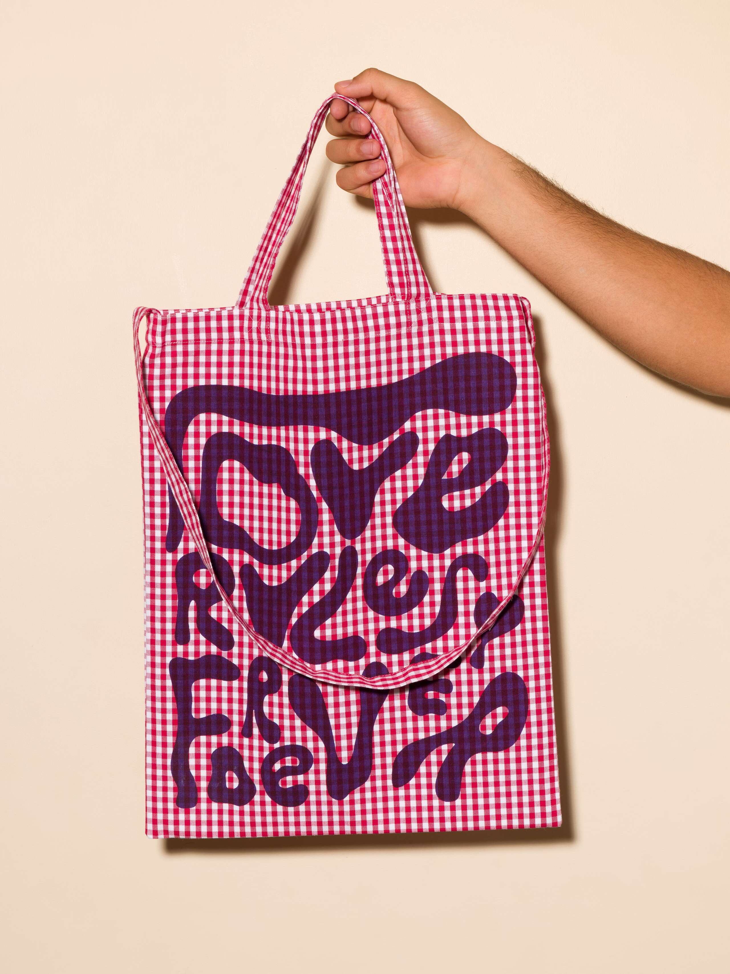 Picture of a tote bag featuring a beautiful check pattern and the motto Love Rules Forever