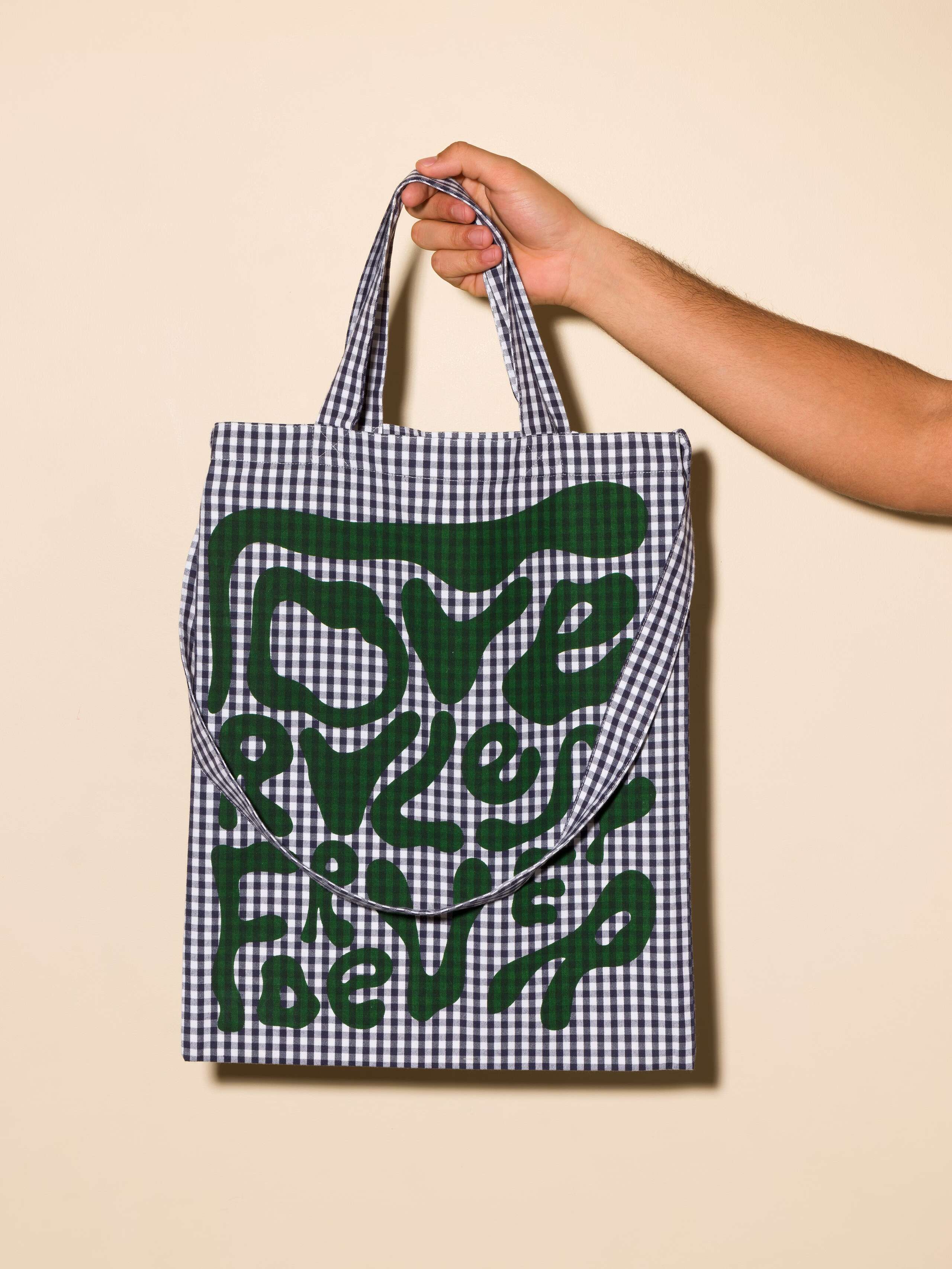Picture of a tote bag featuring a beautiful navy blue check pattern and the motto Love Rules Forever