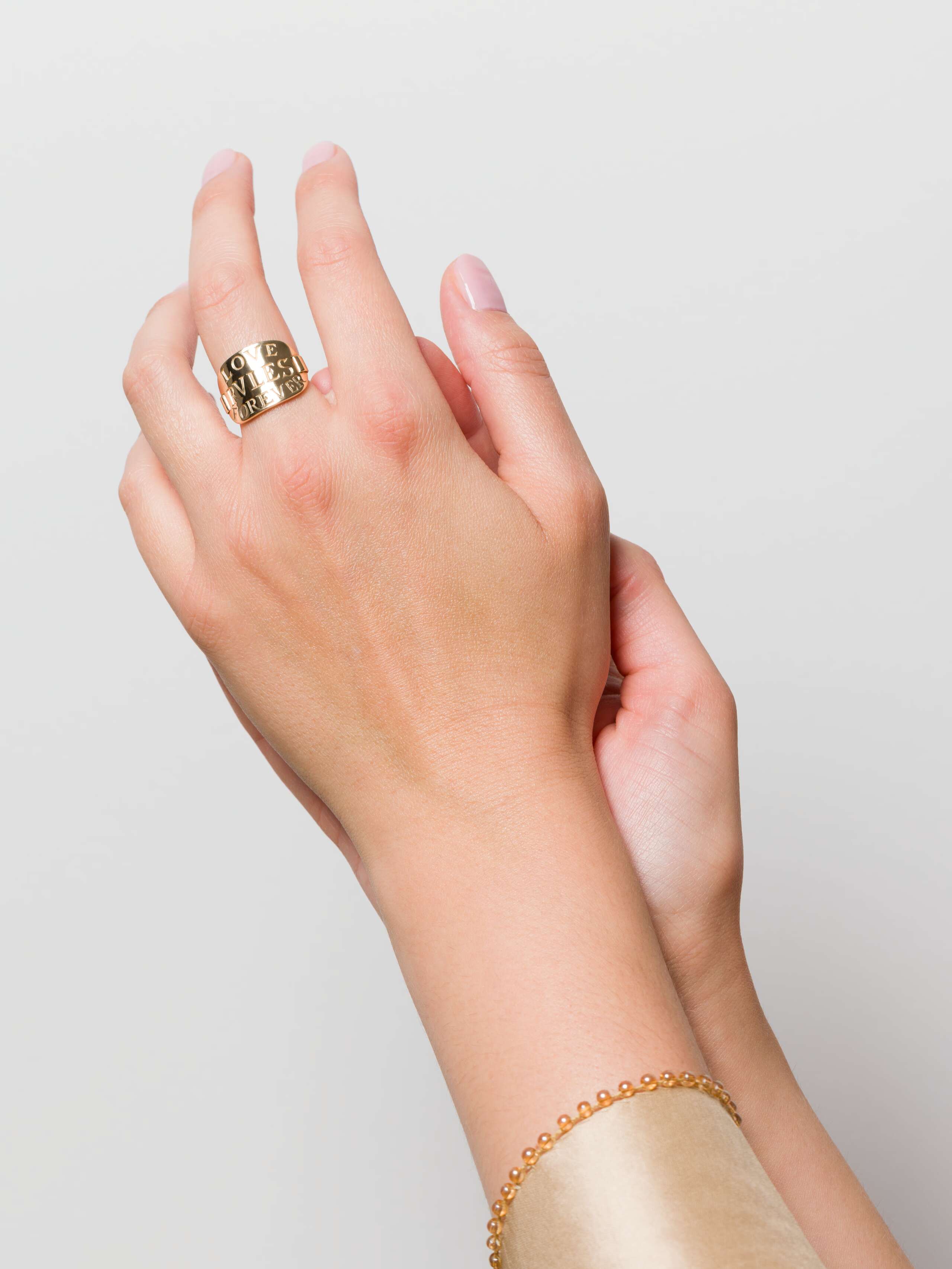 Model wearing Love rules forever tag ring in 9 karat gold