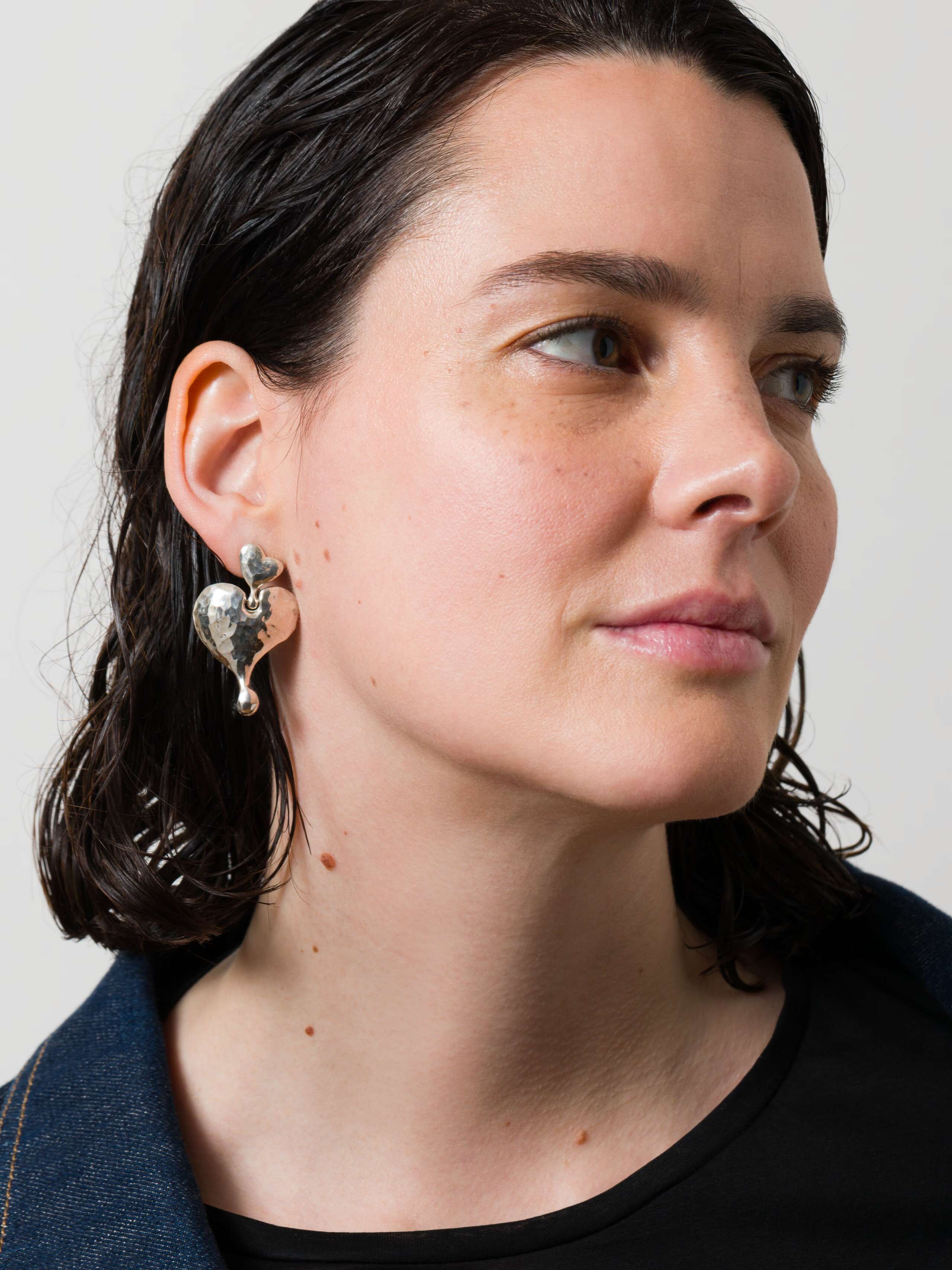 Model wearing soft heart earrings in silver