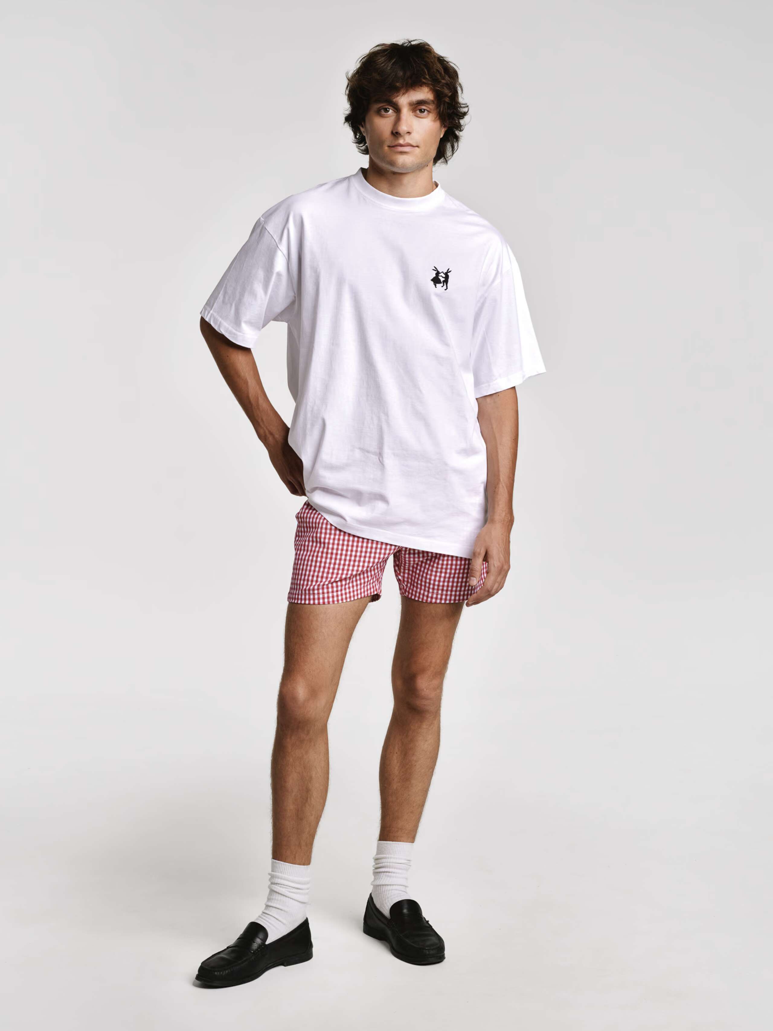 Model wearing Tshirt with the embroidered rabbits logo and Allen shorts in red vichy