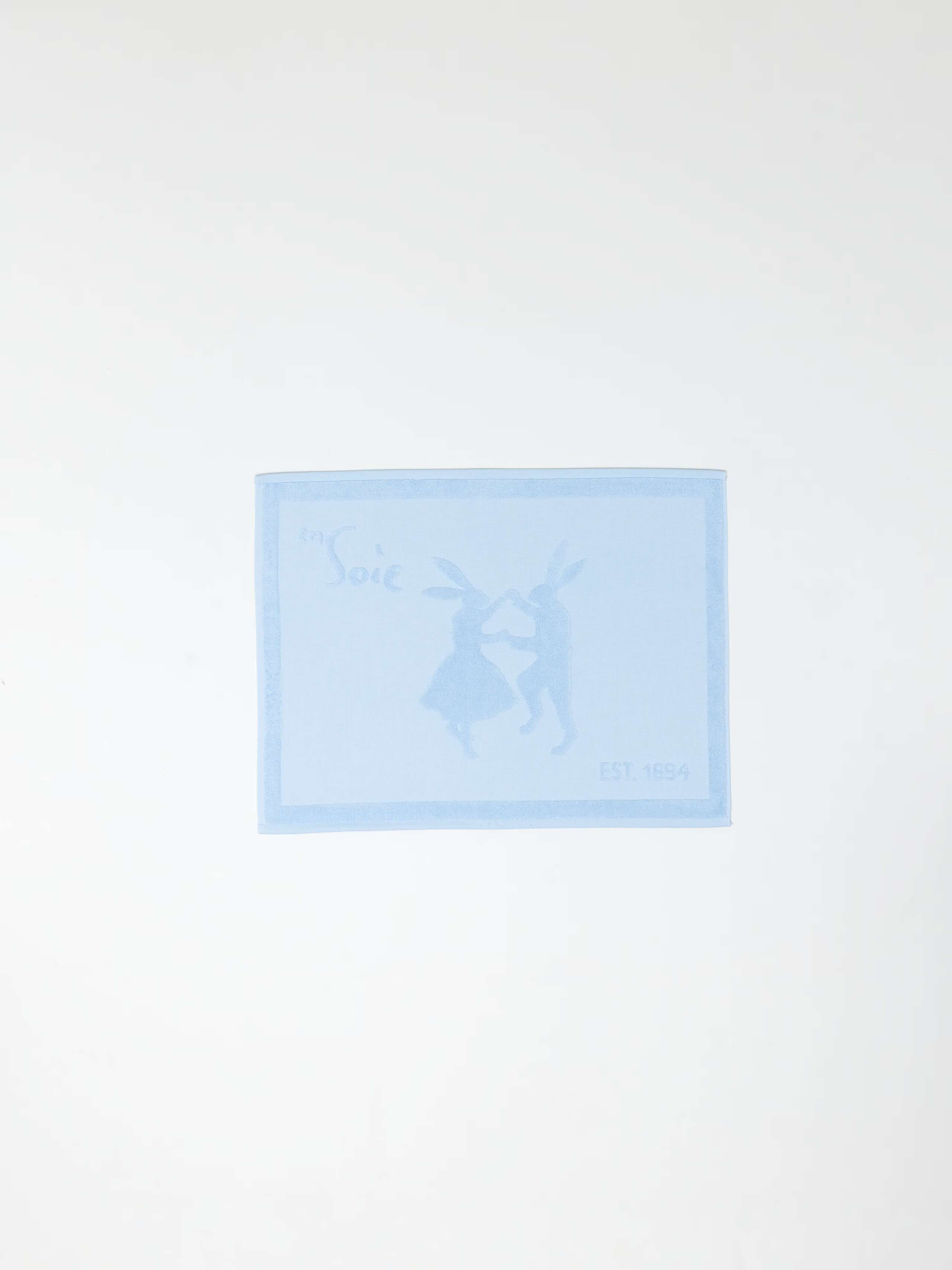 Soft Cerulean Blue terry bath mat with rabbits and logo