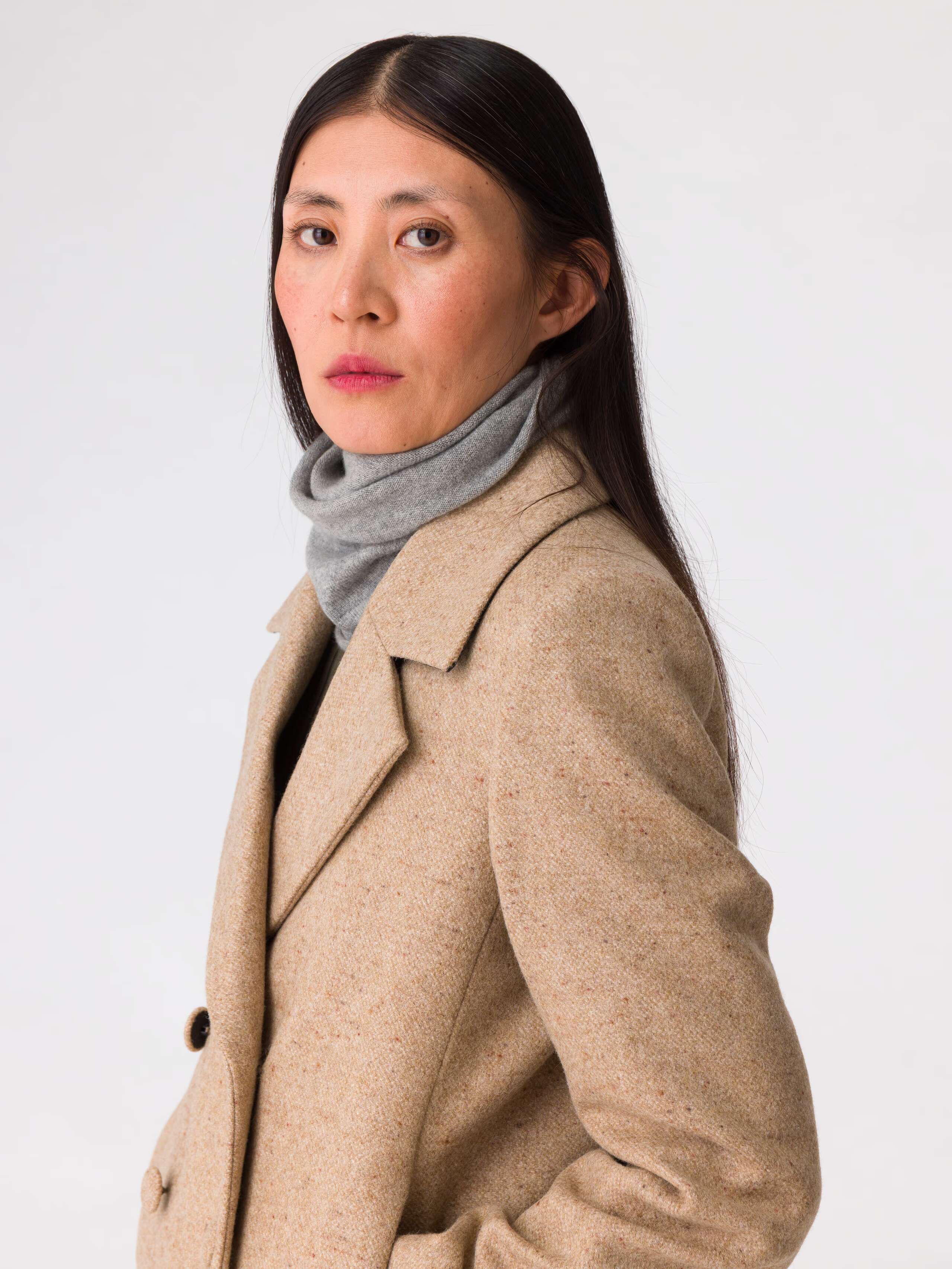 Picture of a women wearing a grey fine knit tube hat made from finest wool and cashmere