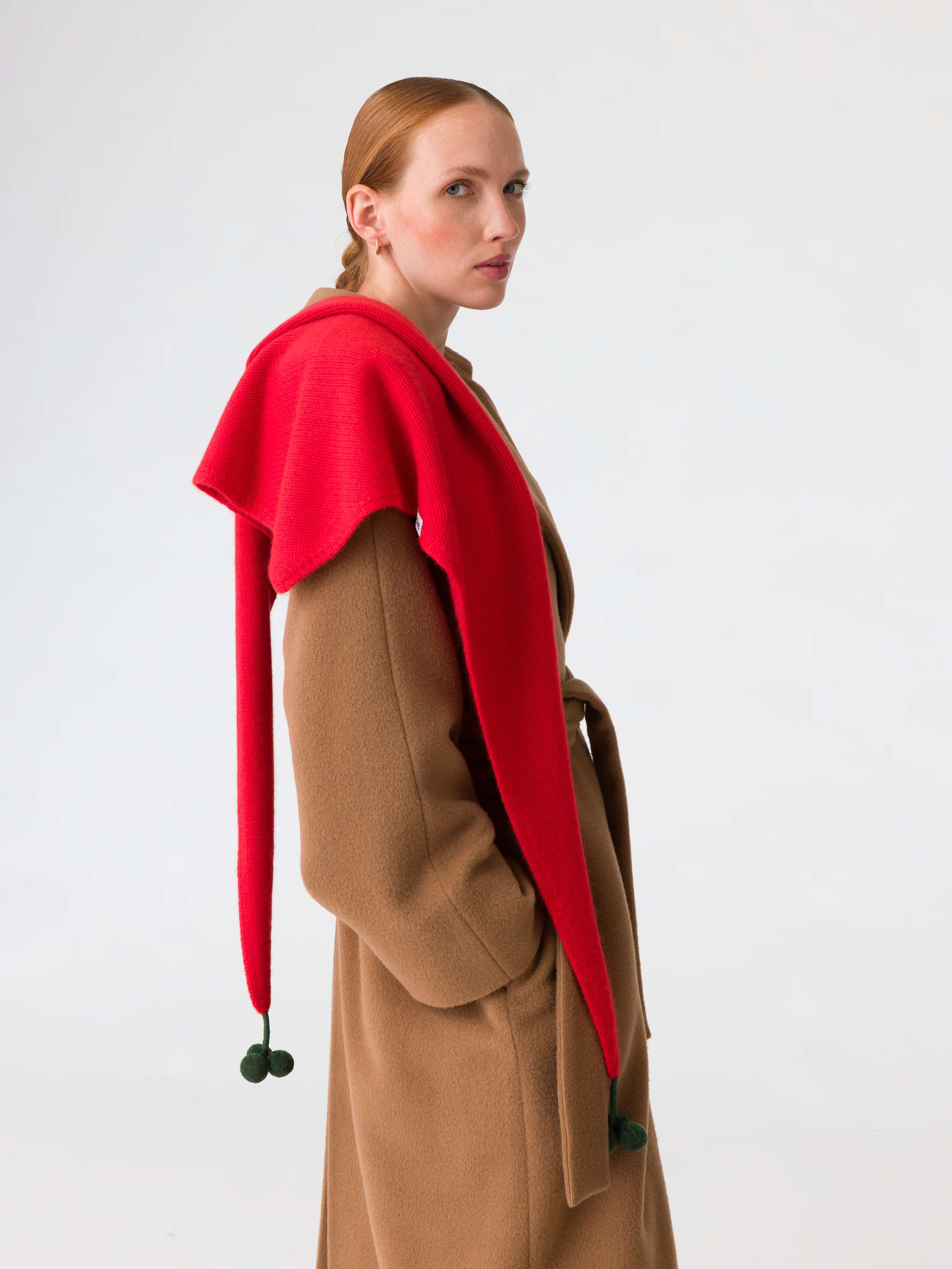 Picture of a model wearing a beige coat in combination with a red cashmere scarf
