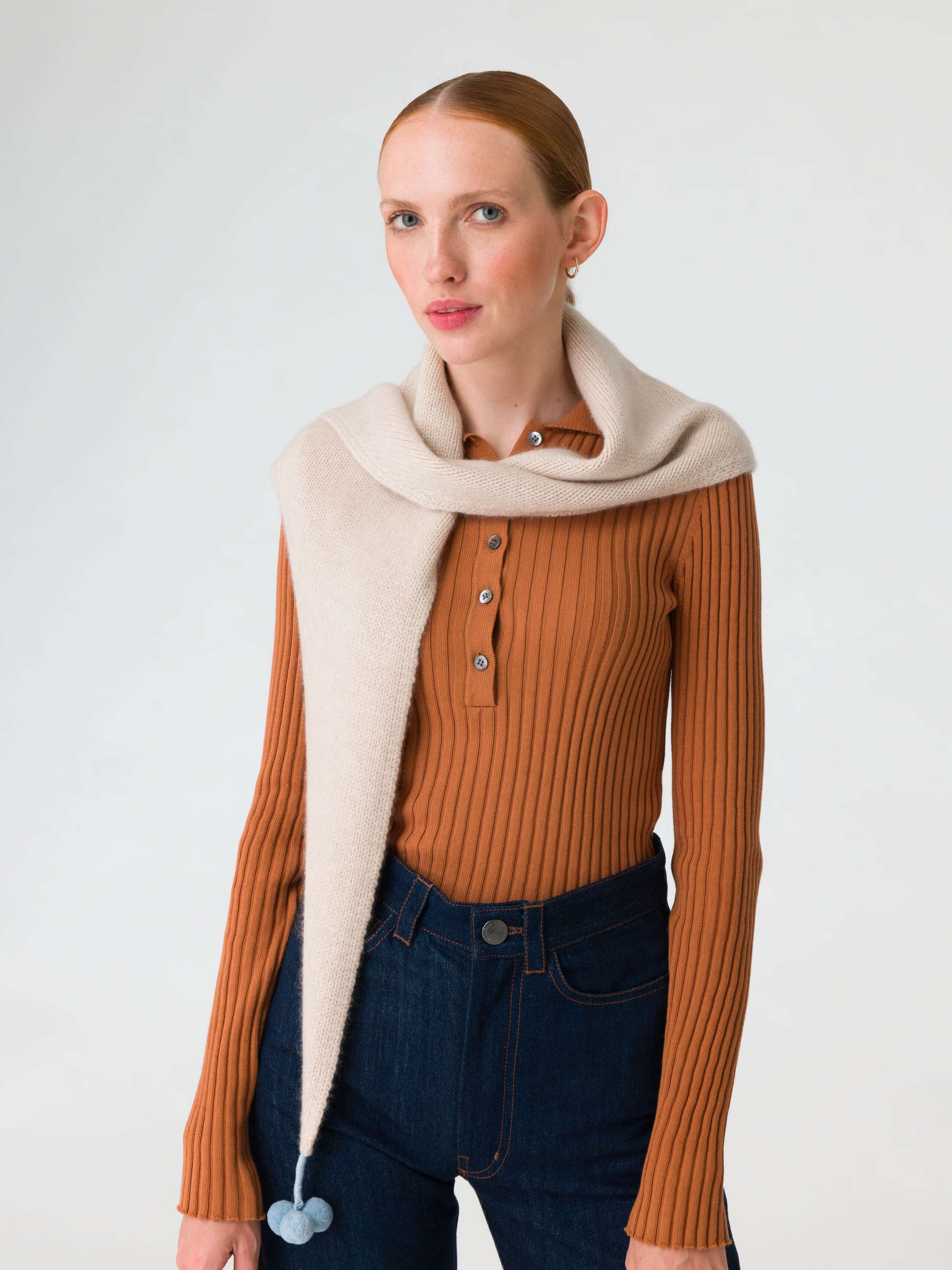 Picture of a model wearing a beige coat in combination with a beige cashmere scarf