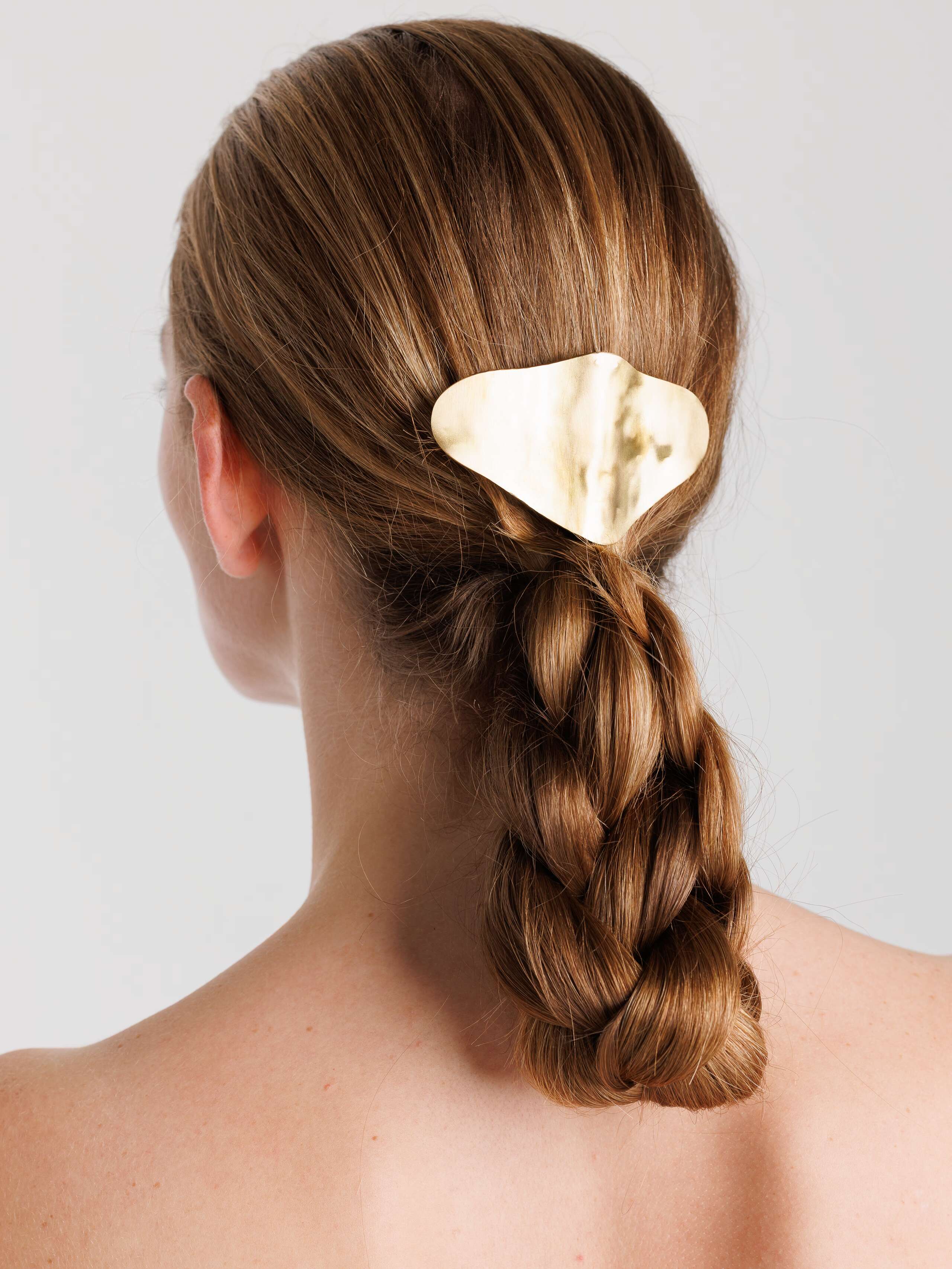 Shape hair clip in brass worn by model