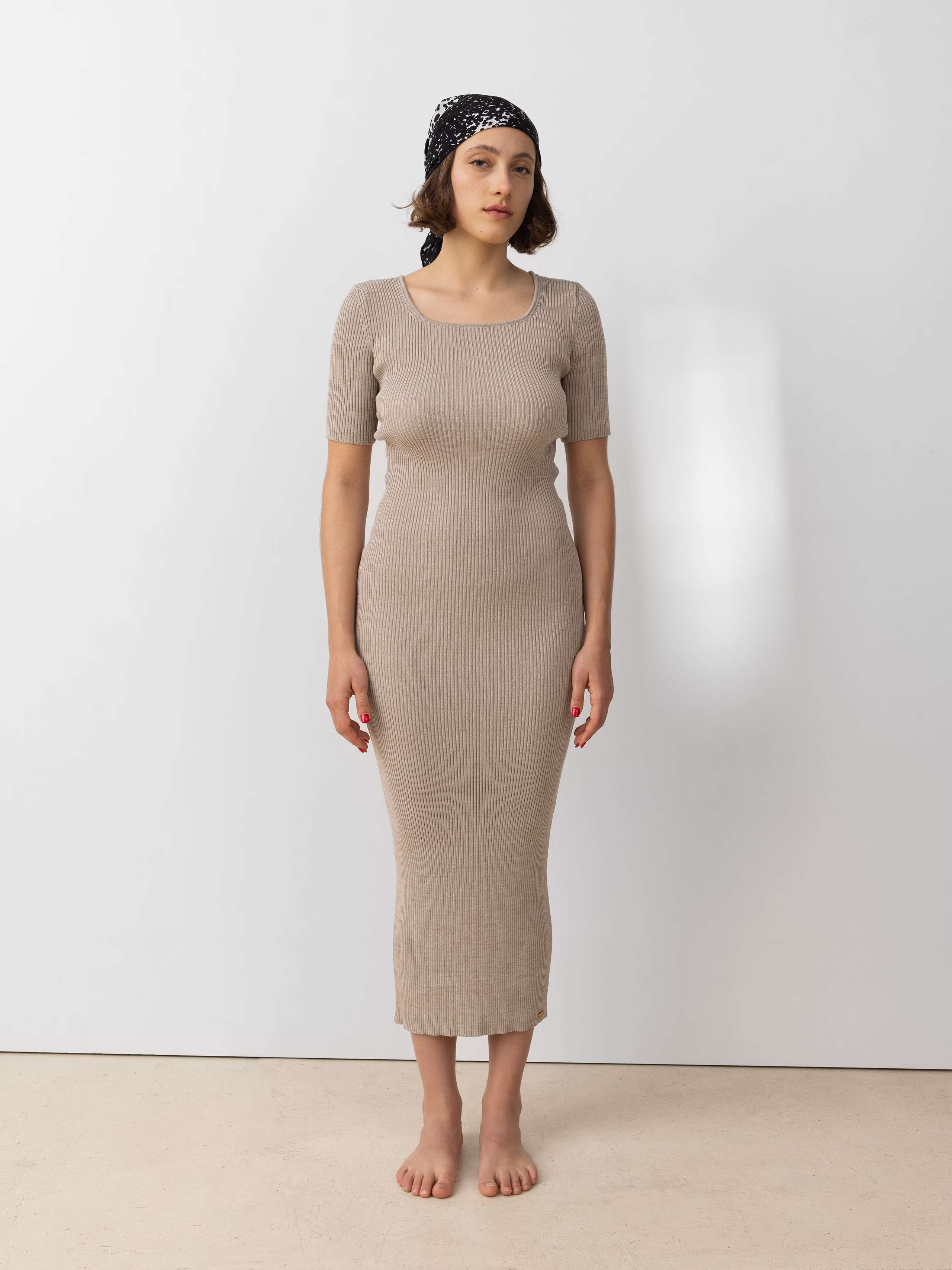 Model wearing the fitted Vicky dress in knitted beige cotton