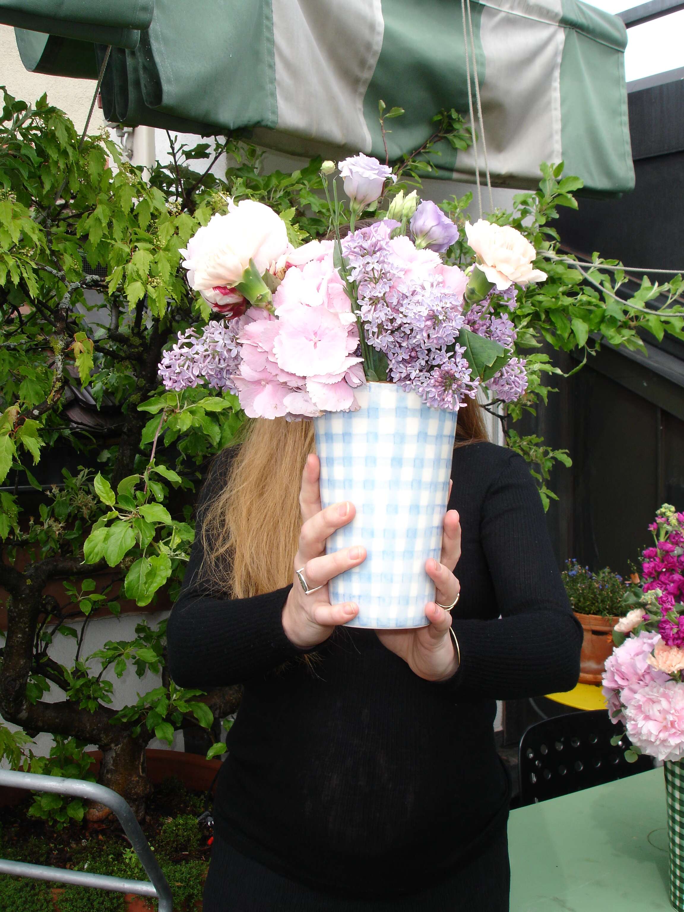 Picture of a women holding a vase filled with flowers