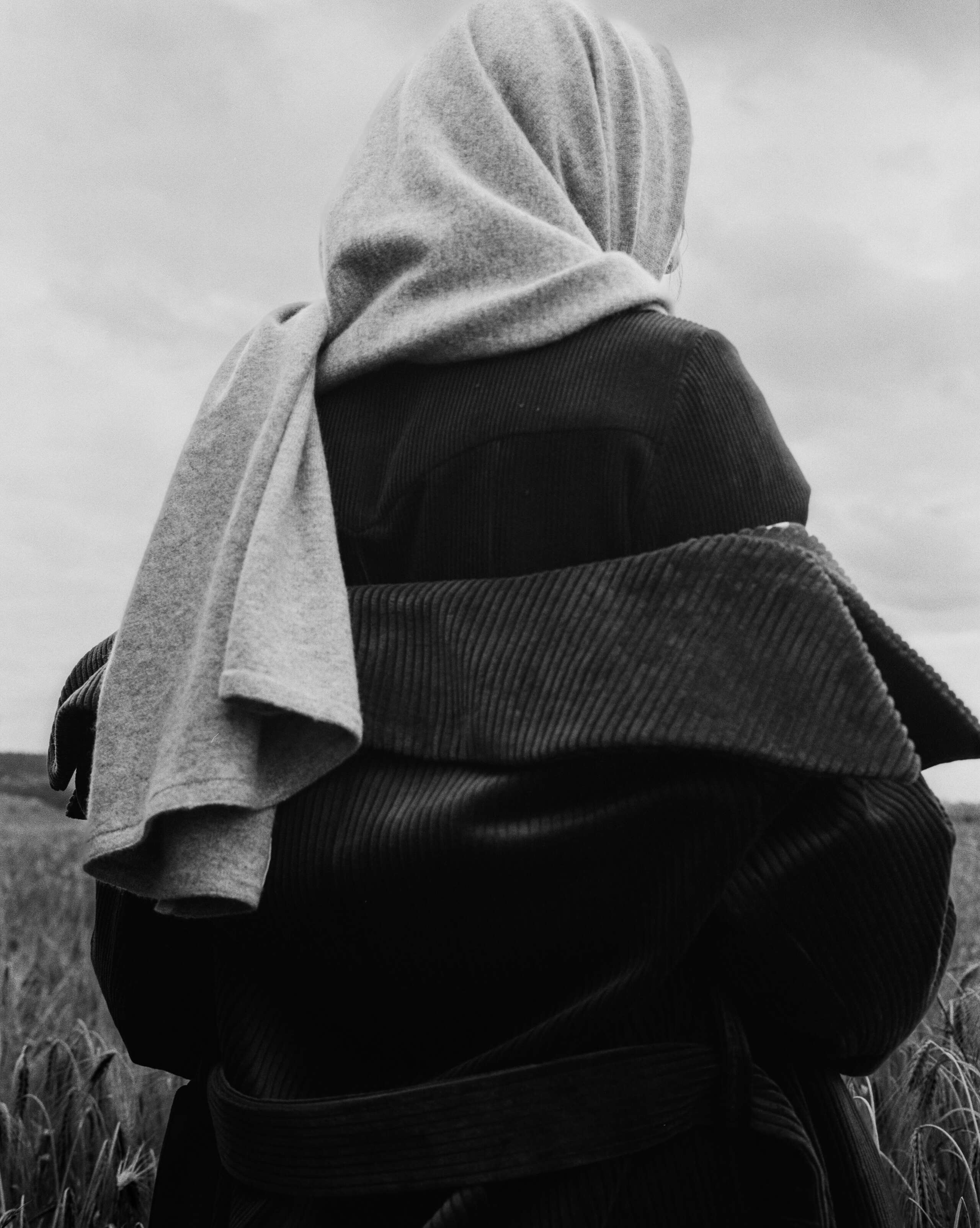 Picture of a female model wearing a grey cashmere scarf